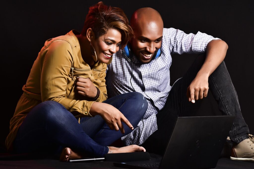 man and woman smiling and shopping on a laptop