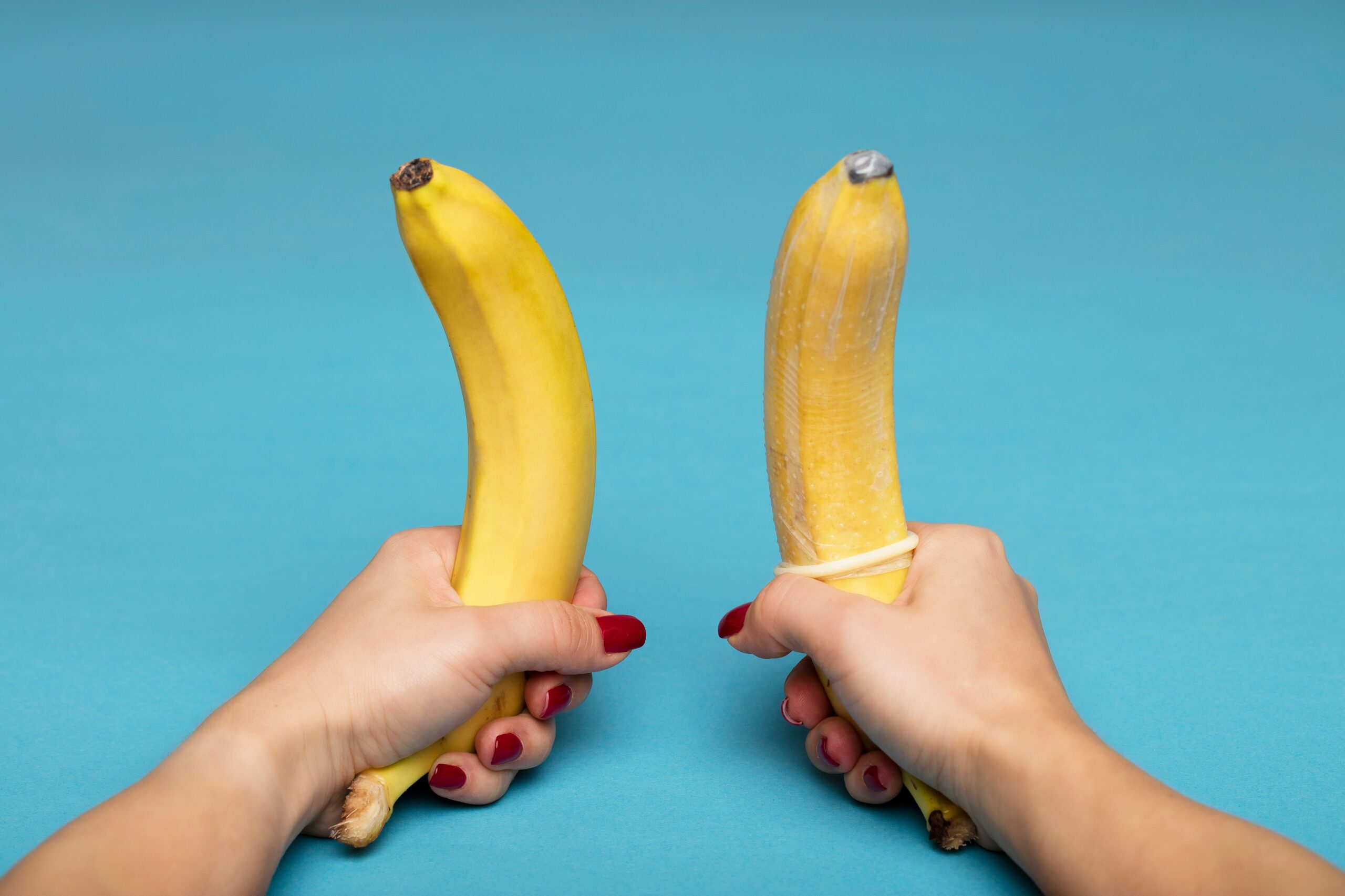 woman holding two bananas with a blue background