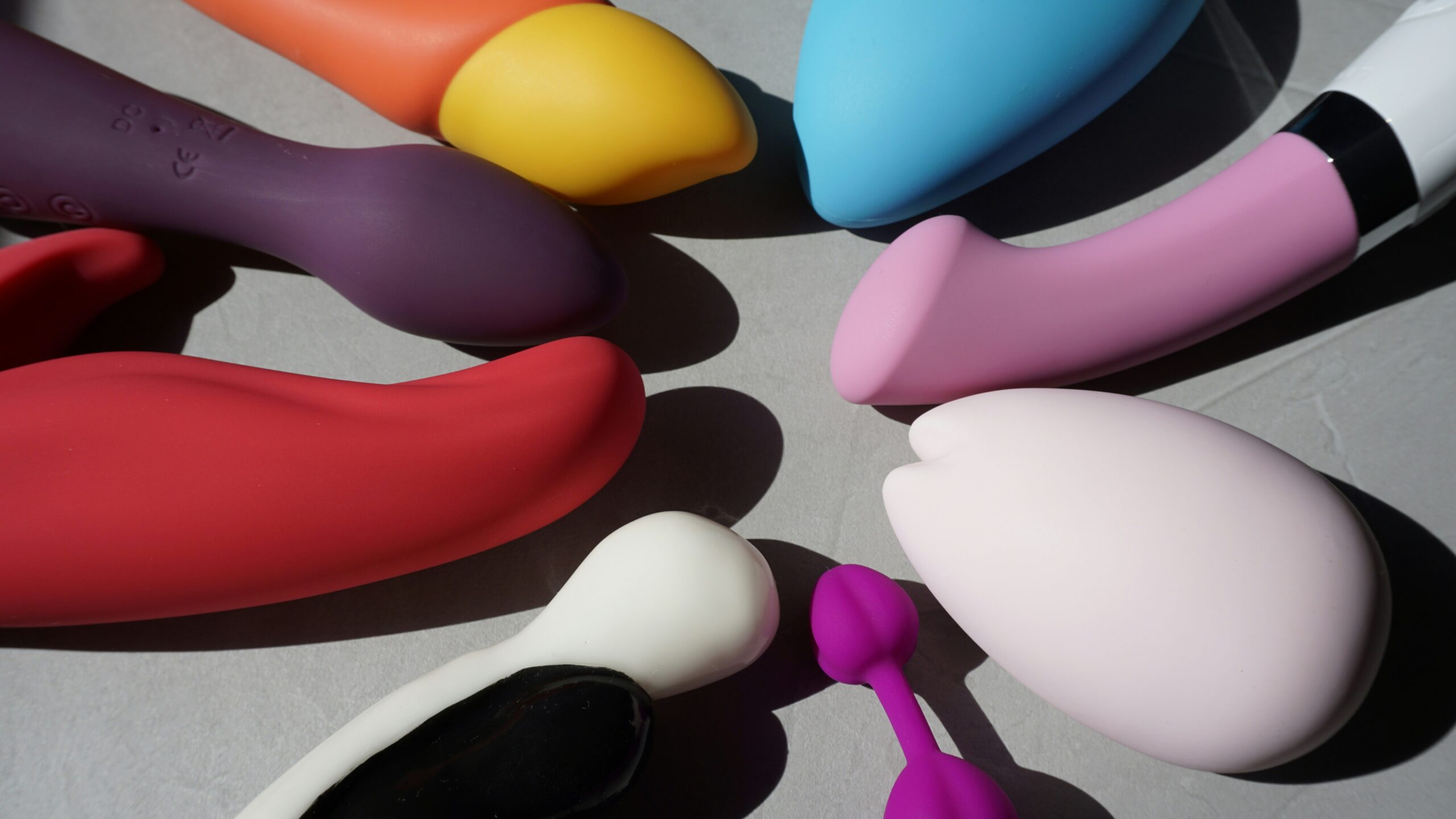 Multicolored sex toys on gray background