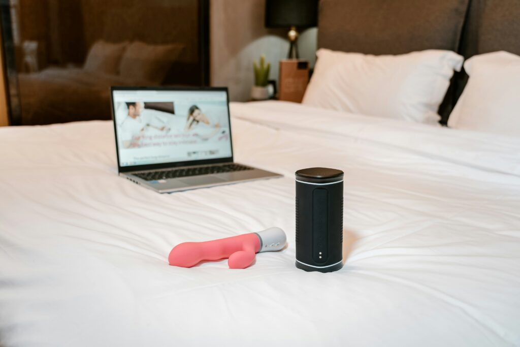 Sex toy and laptop on bed