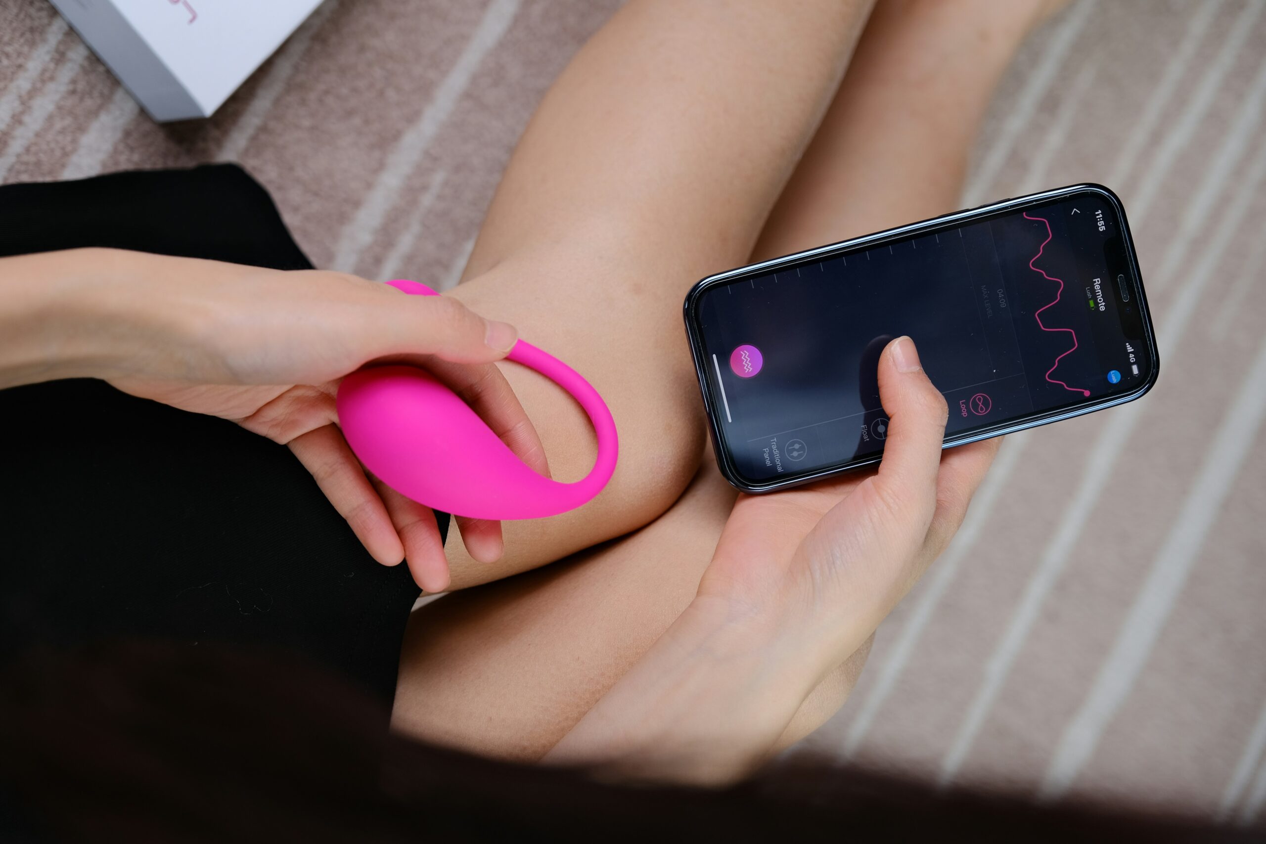 Woman holding pink sex toy and phone
