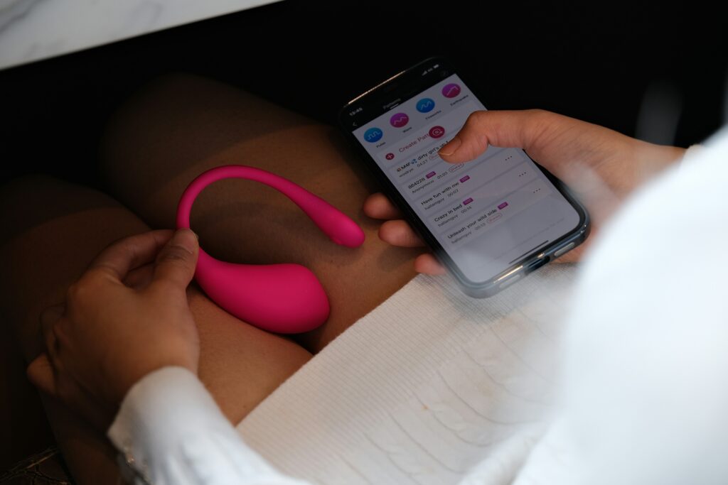woman holding sex toy and phone