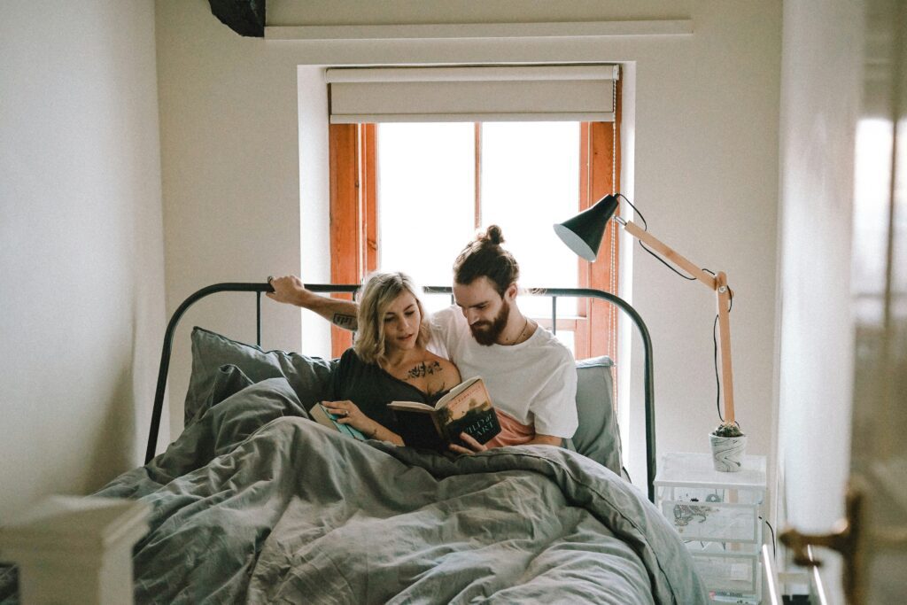 Man and woman in bed reading.