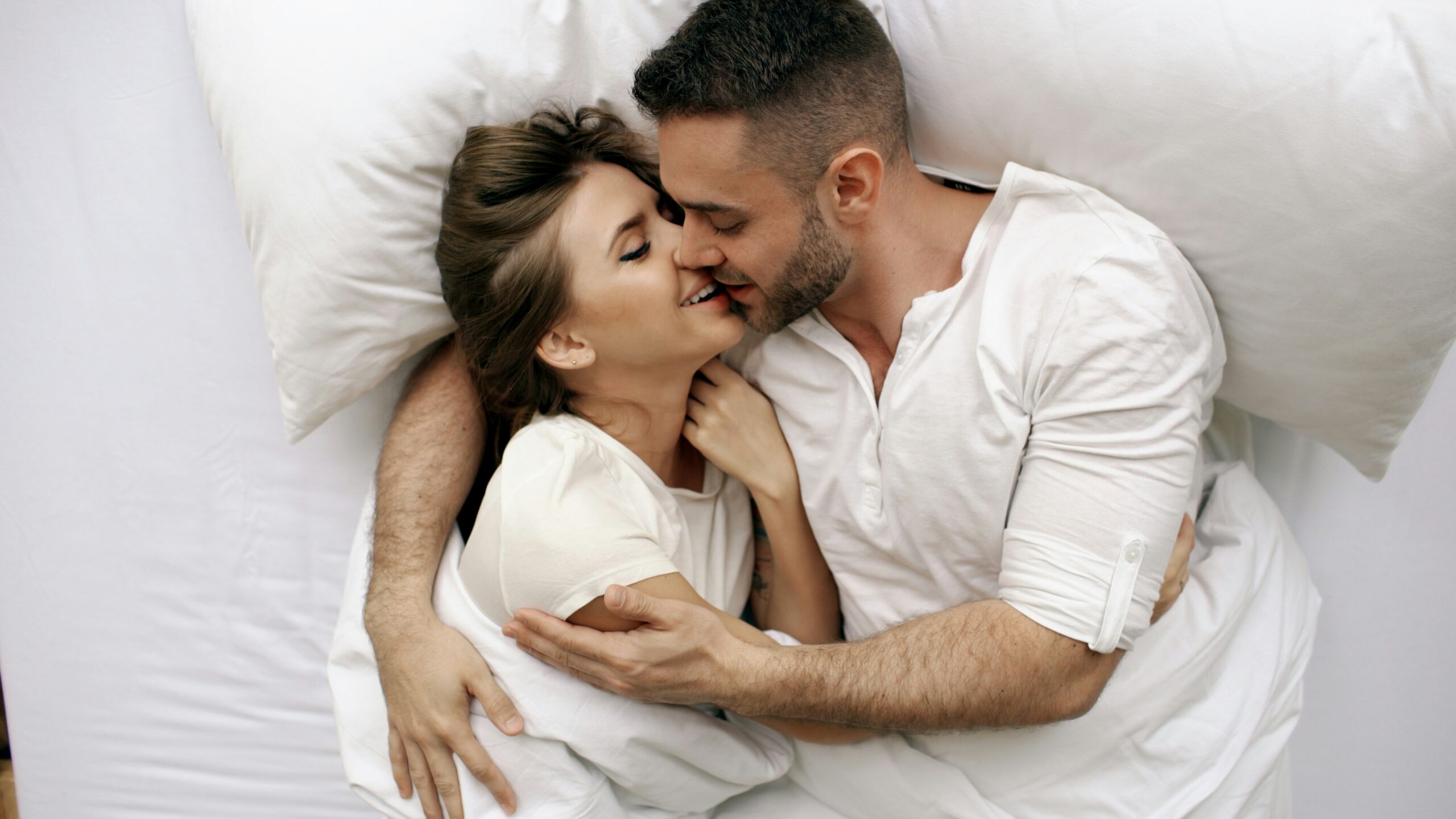 Man and woman cuddling in bed