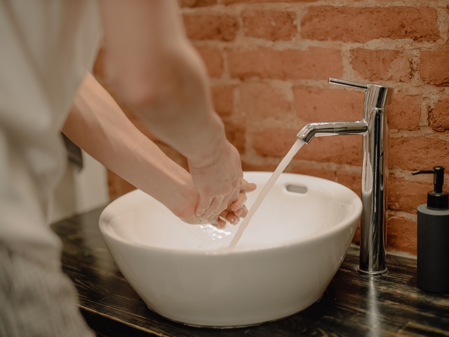 Close-up of hands being washed with soap, representing toy cleaning and hygiene basics