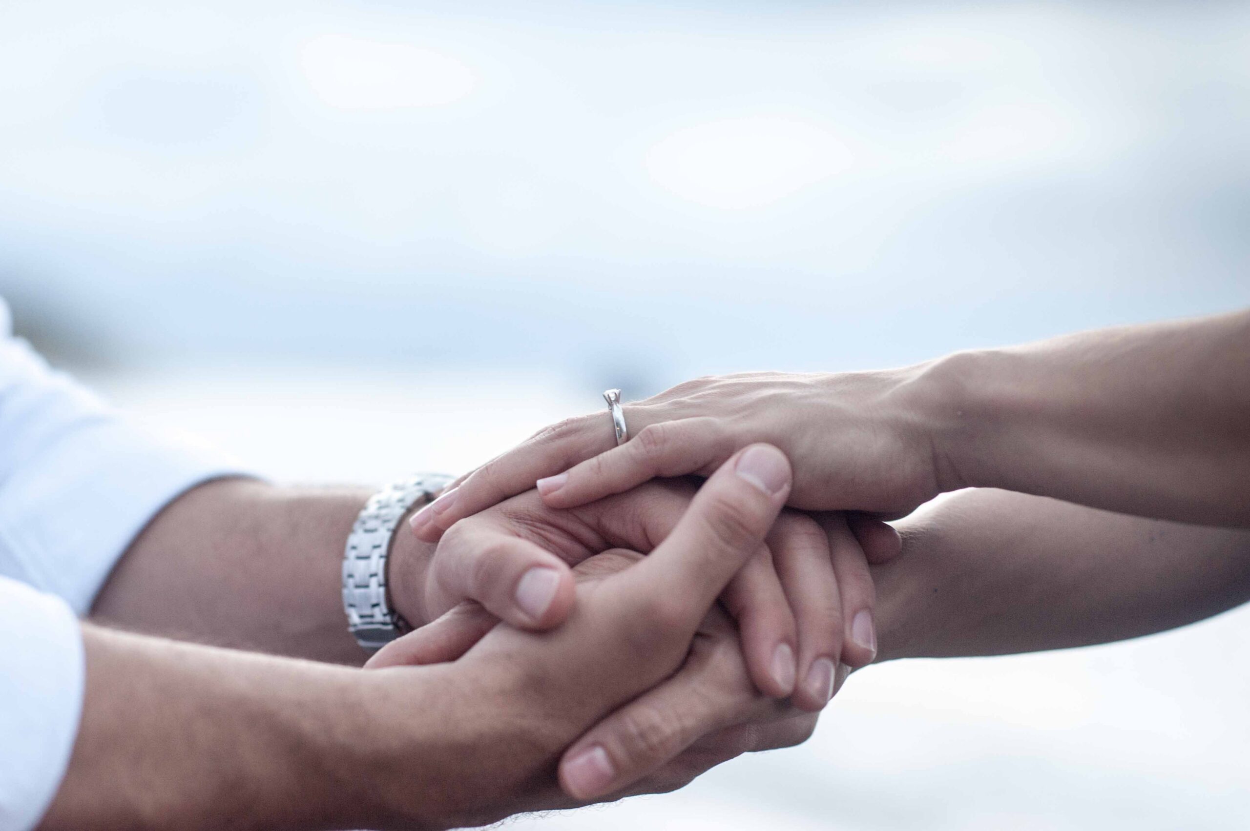 Close-up of a couple holding hands, representing trust and connection