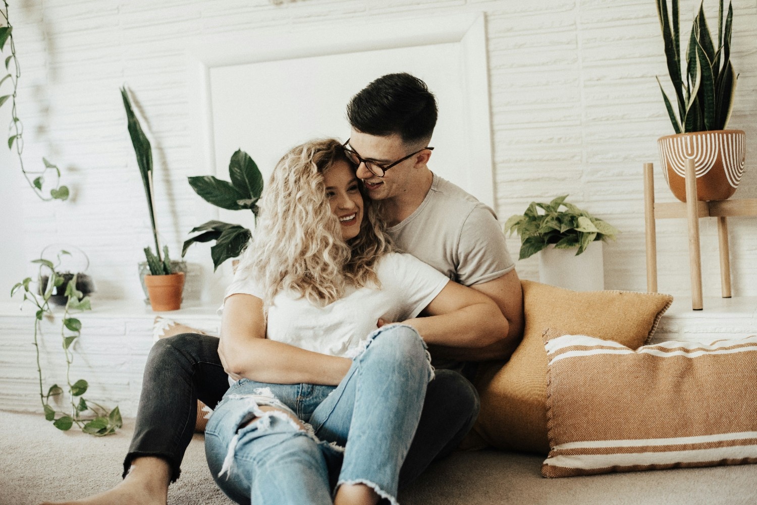 Couple laughing together on a couch, representing a relaxed conversation about trying something new