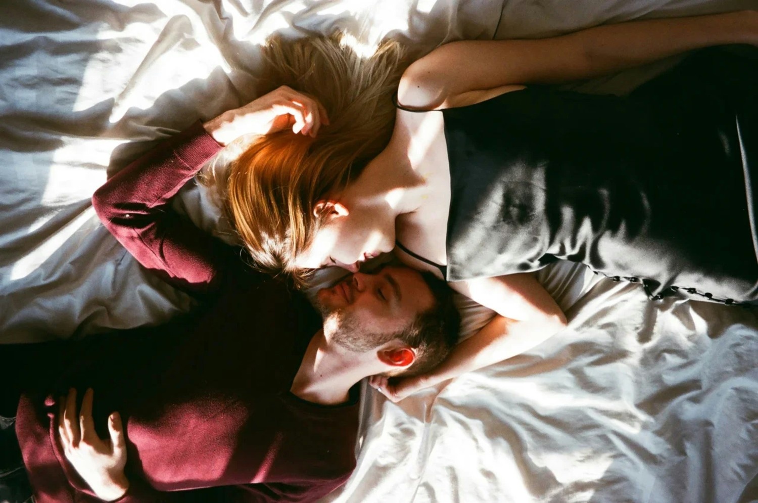 Woman and man in bed in sunlight