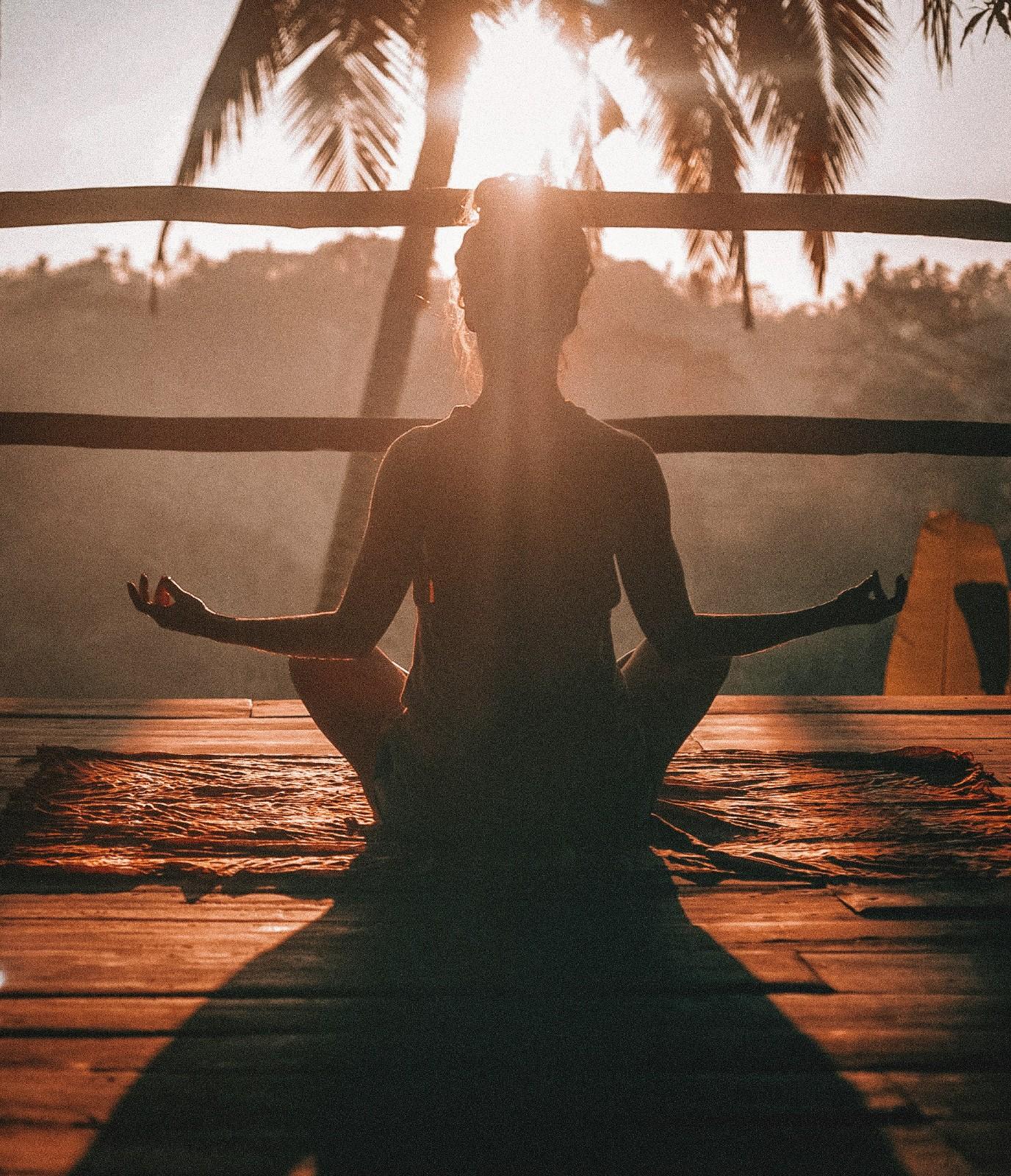 Woman meditating with sun shining