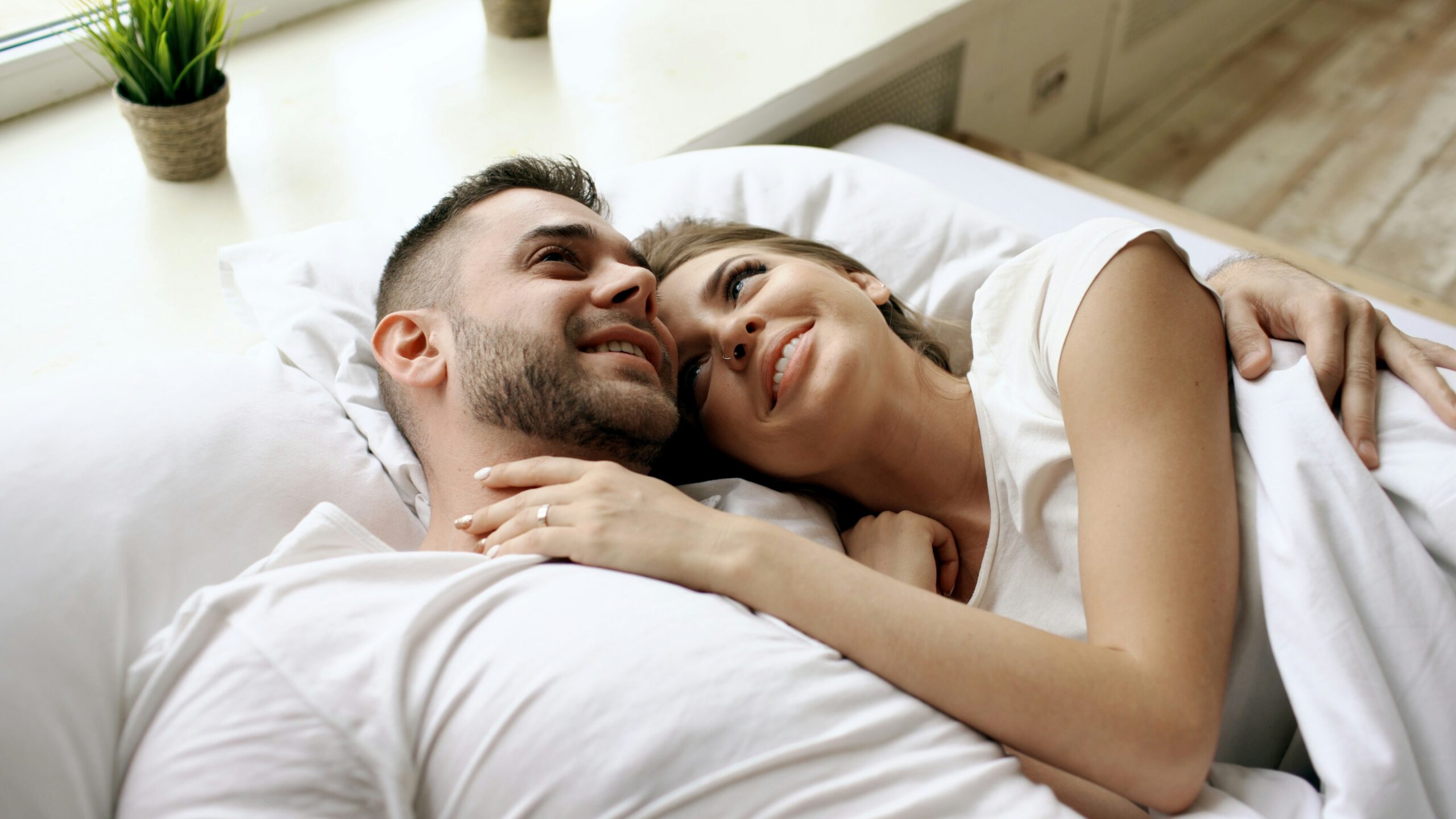 Man and woman embracing in bed