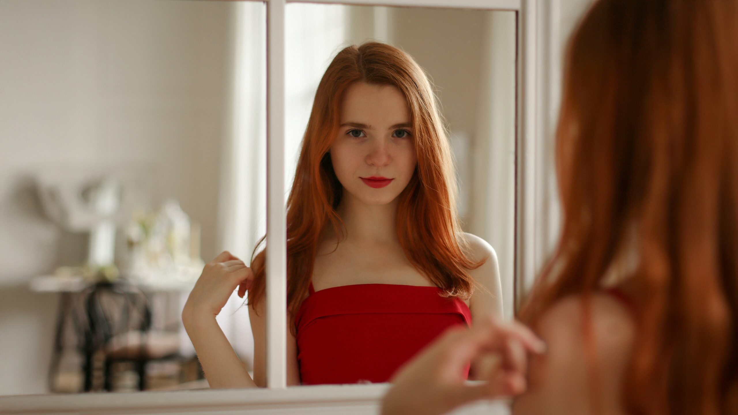 Red-haired woman looking in a mirror