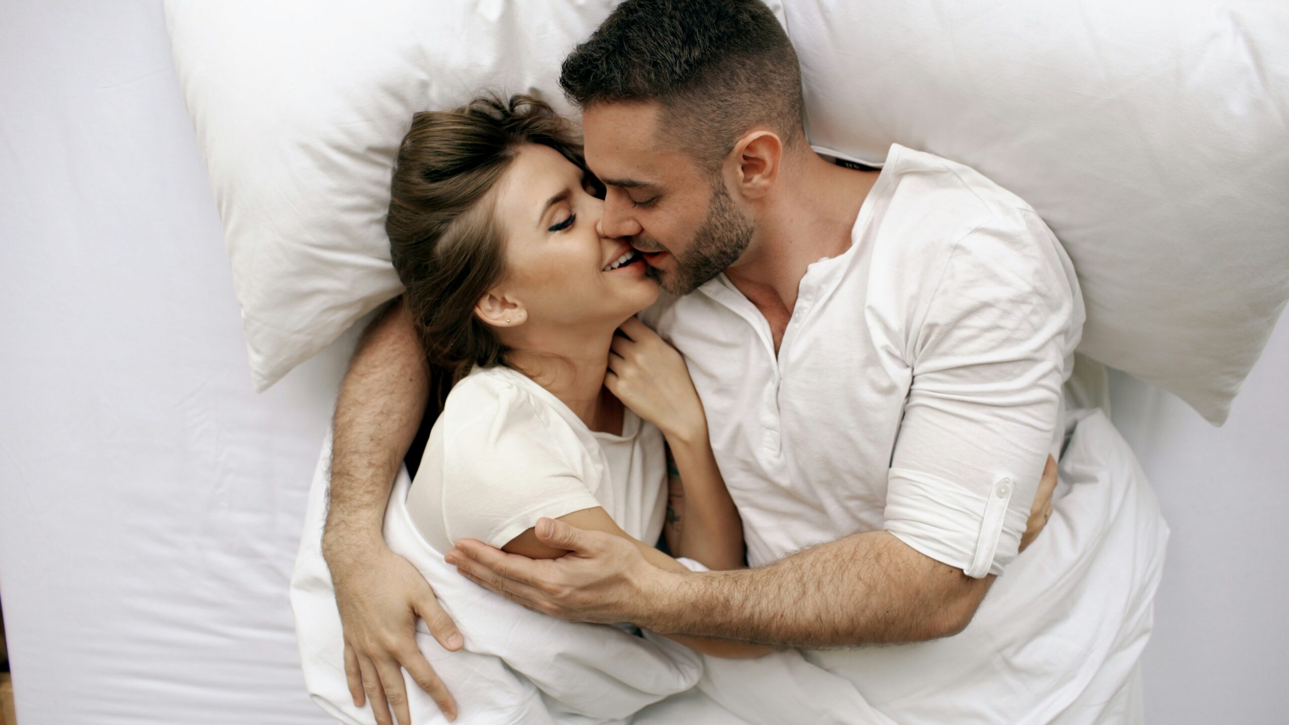 Woman and man dressed in white in bed