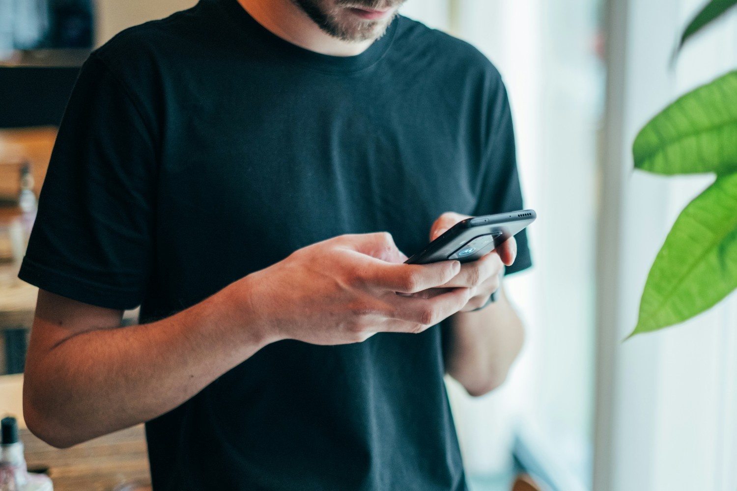 Man in black shirt texting