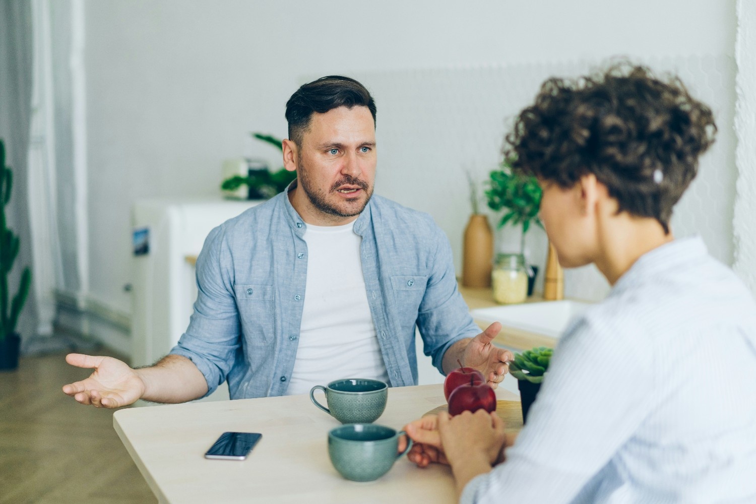 Man sitting at table talking to woman