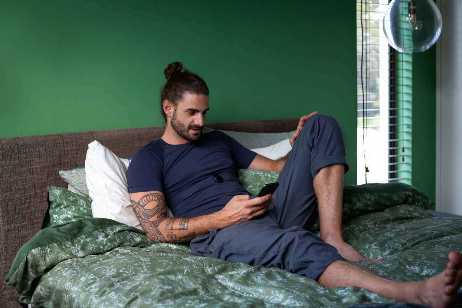 Man on phone in a green bed