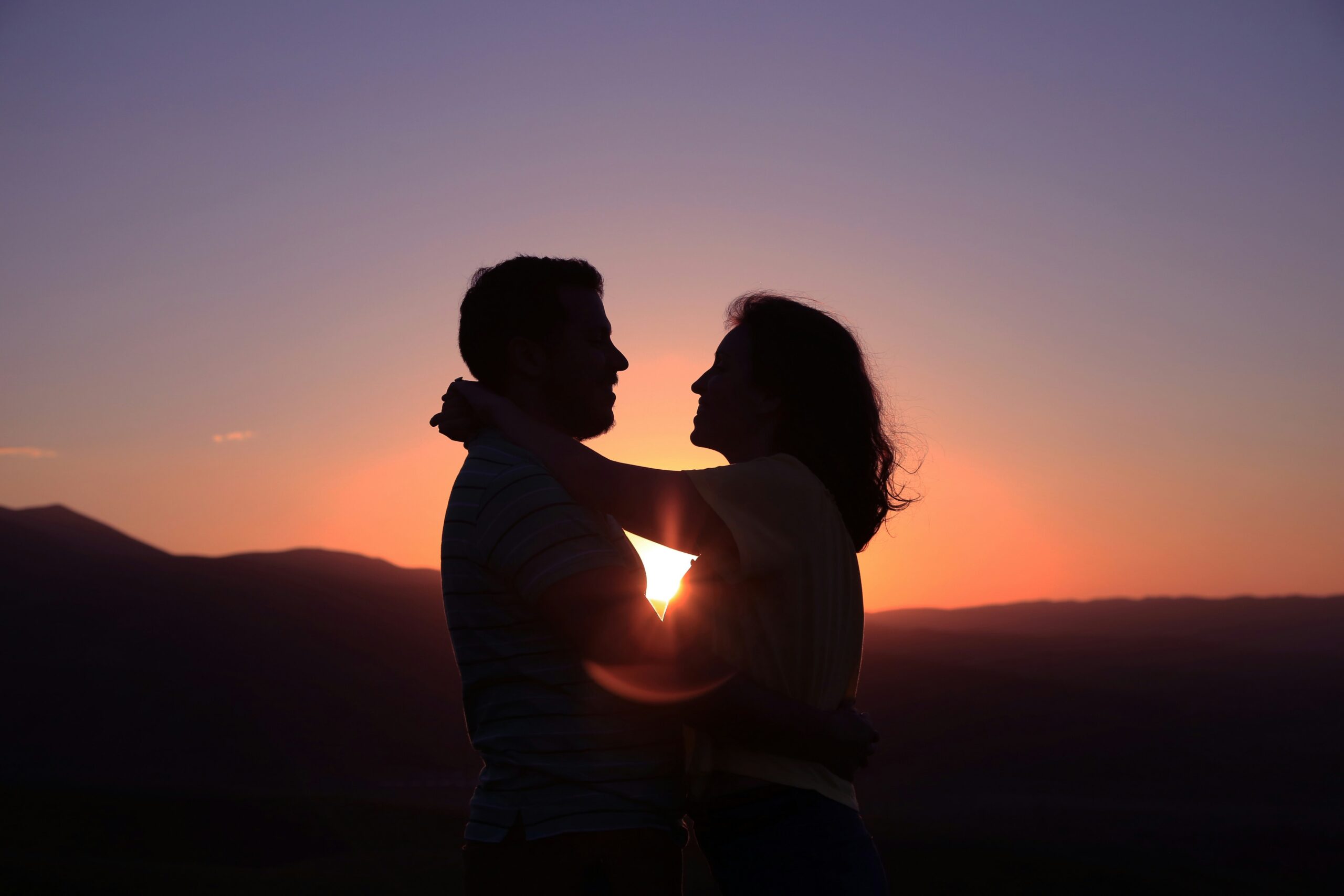Silhouette of a couple hugging at sunset