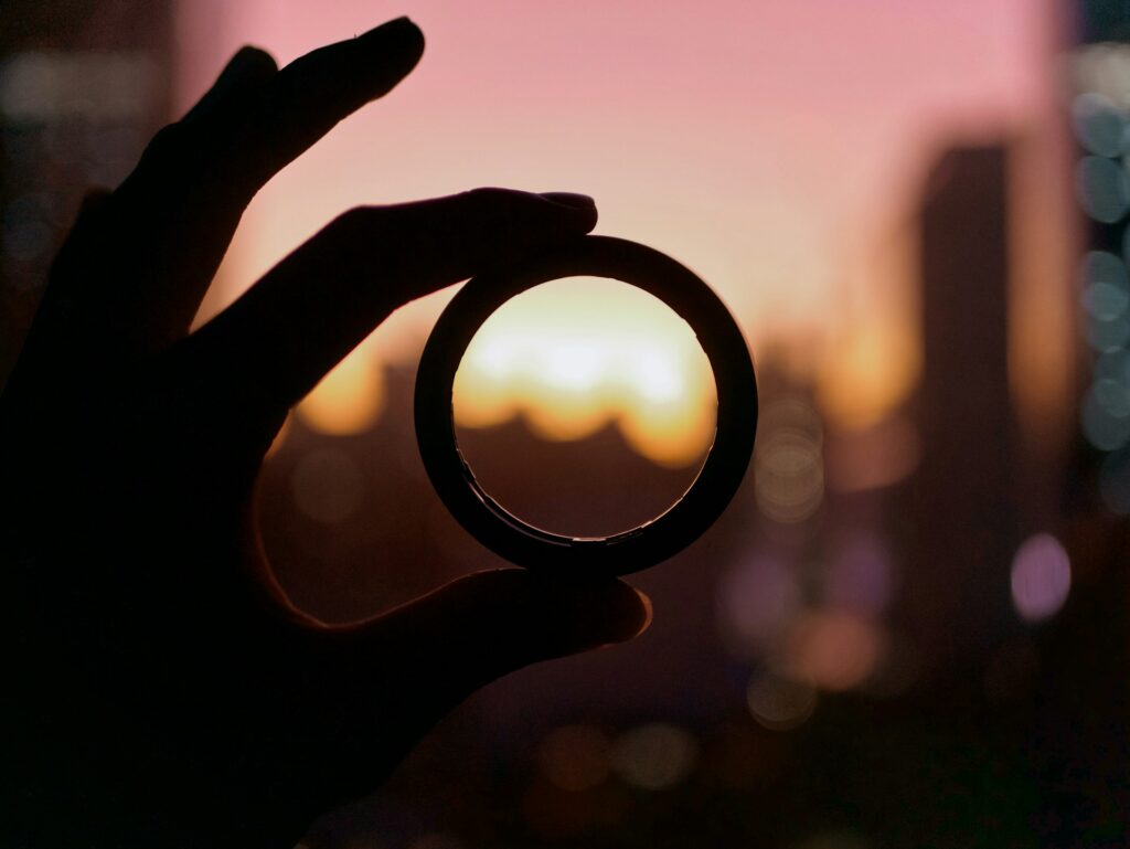 Person holding ring up to skyline